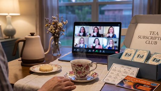 Virtual tea party on a laptop screen beside a teacup and kettle on a kitchen table