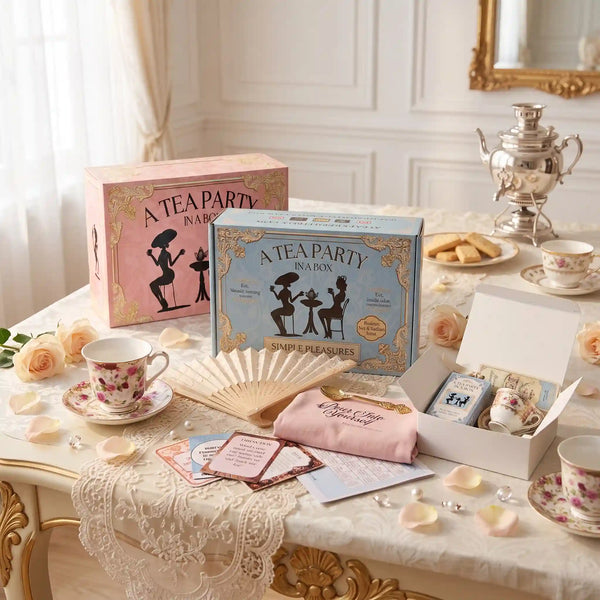 Three tea party in a box gift boxes on a table: Simple Pleasures with a teacup, the Mini box, and the Party Kit for 8