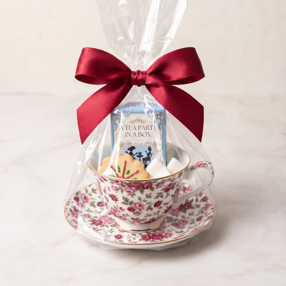Cottage Bouquet teacup and saucer gift set in cellophane with a red bow, tea box, cookie and sugar cubes