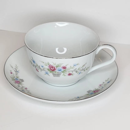 Flower Basket teacup and saucer with a small woven basket of pink and blue flowers, gray scrolls, silver-tone rim