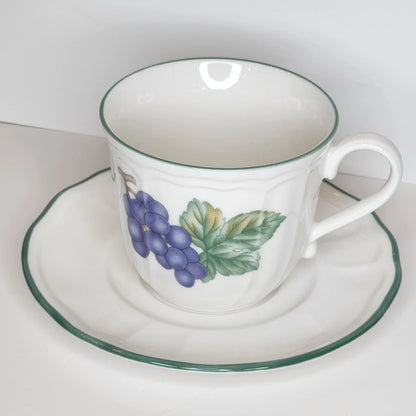 Grapevine teacup and saucer with a cluster of purple grapes and green leaves on white, fluted sides, green rim