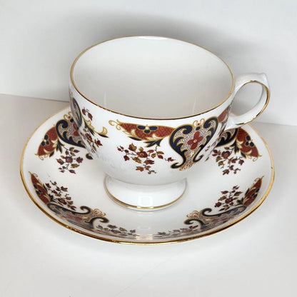Heirloom Paisley teacup and saucer with navy and rust red paisley scrolls, small russet flowers, and a gold-tone rim