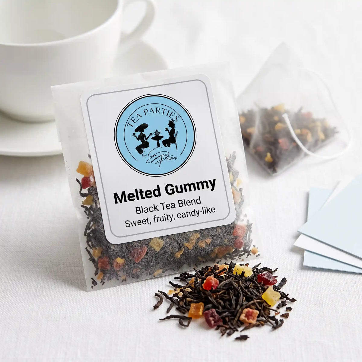 Melted Gummy loose leaf tea sachet with the Tea Parties by Erica Powers label, black tea blend, dark twisted black tea leaves mixed with small colorful dried fruit pieces in red