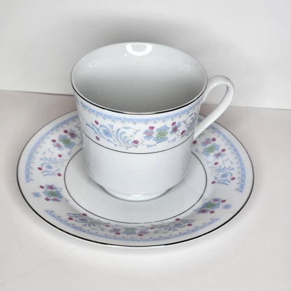Pink Posy teacup and saucer with bright pink flowers, green rosettes and blue scrolls, silver-tone rim