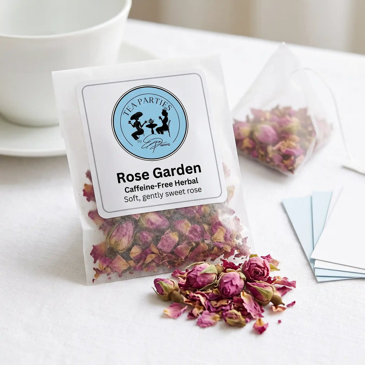 Rose Garden loose leaf tea sachet with the Tea Parties by Erica Powers label, caffeine-free herbal, whole dried pink rose buds and loose pink rose petals
